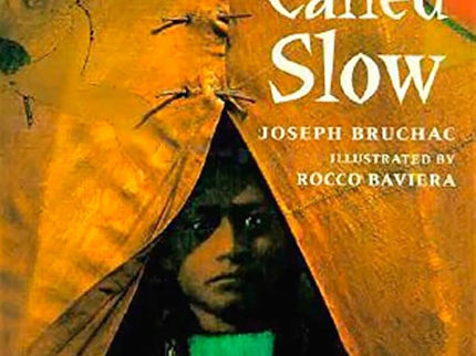 Cover of the book 'A Boy Called Slow' by Joseph Bruchac with illustrations by Rocco Baviera, featuring a young person peeking out from behind a tear in a blanket.