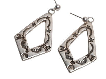 Pair of silver earrings with intricate designs on a white background