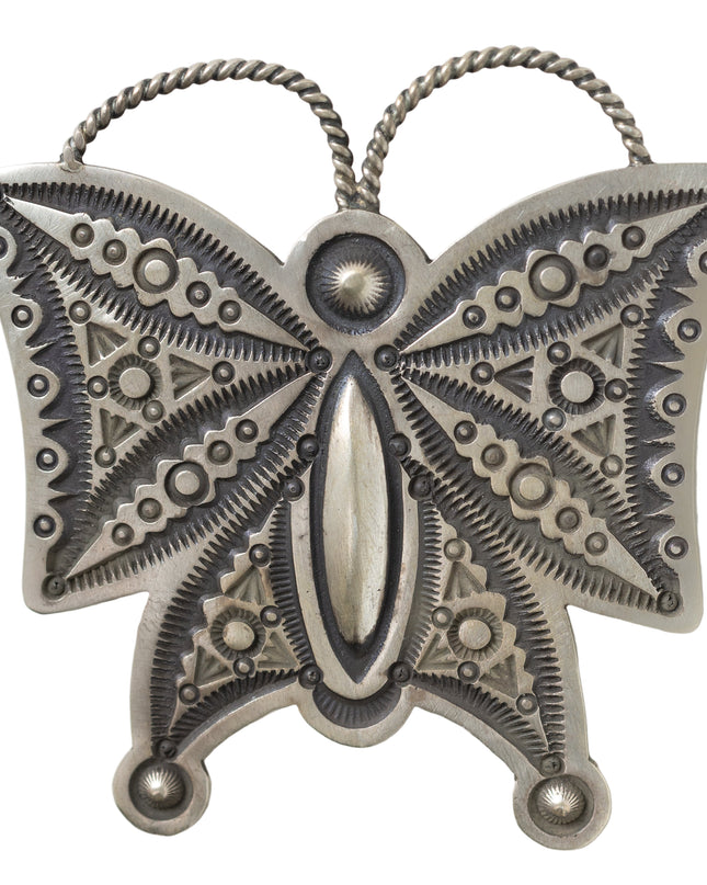 Hand stamped silver butterfly pendant on a white background