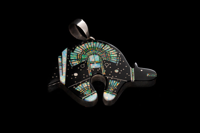 Jet black bear shaped inlay Navajo pendant with a Yei on the surface in opal on a black background