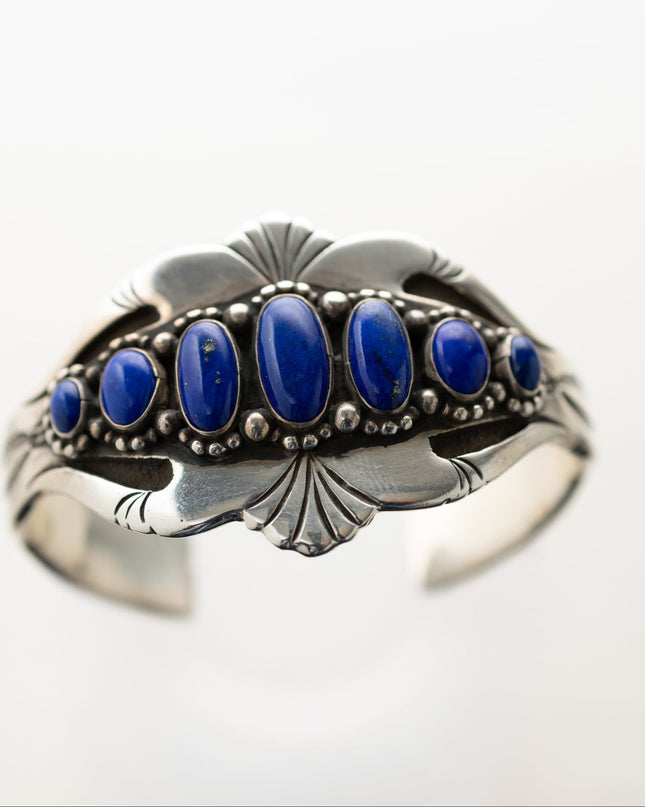 Silver stamped bracelet with lapis stones on a white background