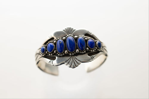 Silver stamped bracelet with lapis stones on a white background