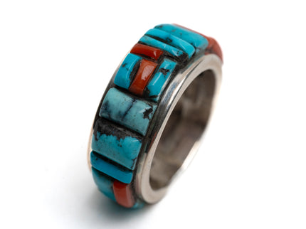 Ring with turquoise and coral stone inlay on a white background