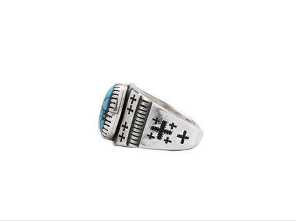 Navajo silver and turquoise ring with black stamped crosses displayed on a white background
