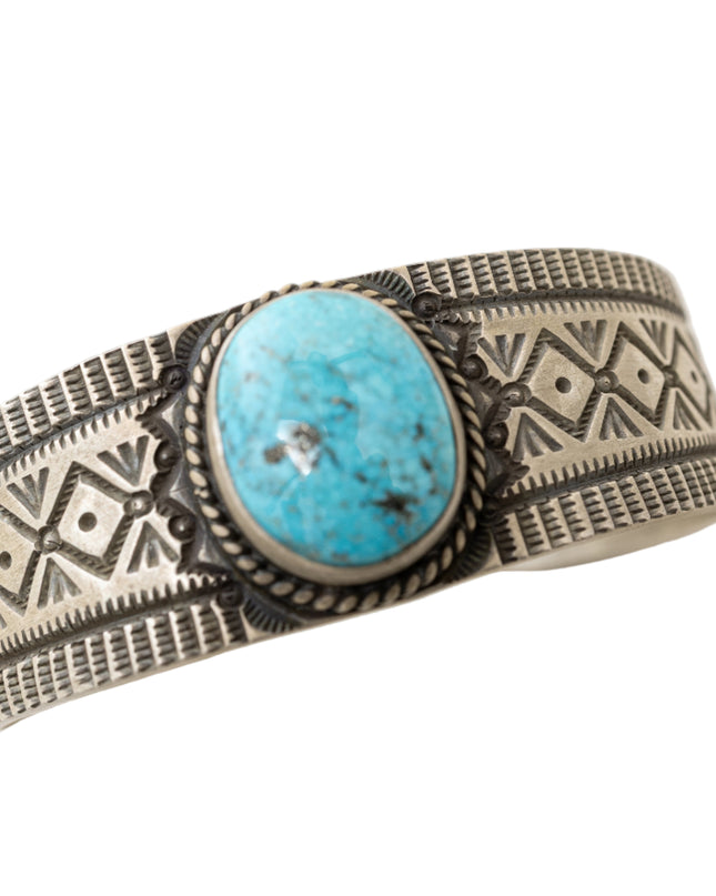 Silver bracelet with turquoise stone on a white background