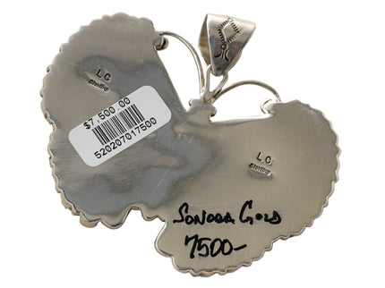 Back of a silver pendant with Lee Charley hallmark engraving on a white background
