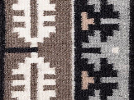 Close-up of a Navajo rug with geometric designs in black, white, and gray.