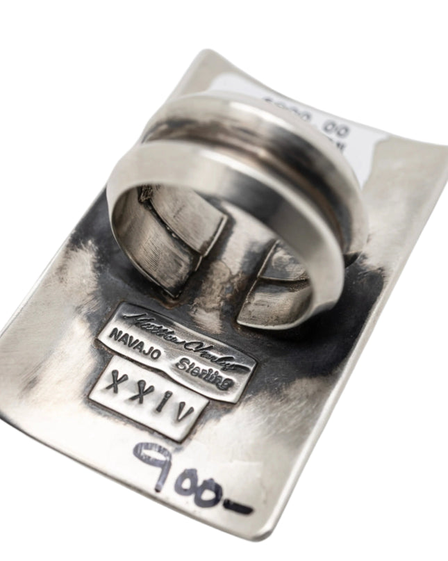 Silver ring with engraved details on a white background