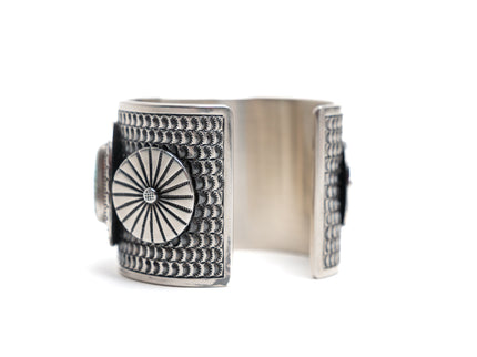 Silver ring with intricate design on a white background