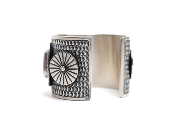 Silver ring with intricate design on a white background