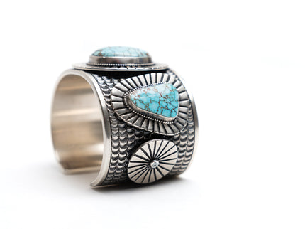 Native American silver cuff bracelet with turquoise stones on a white background