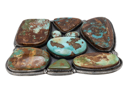 Belt buckle with nine Royston genstones inlay on a white background