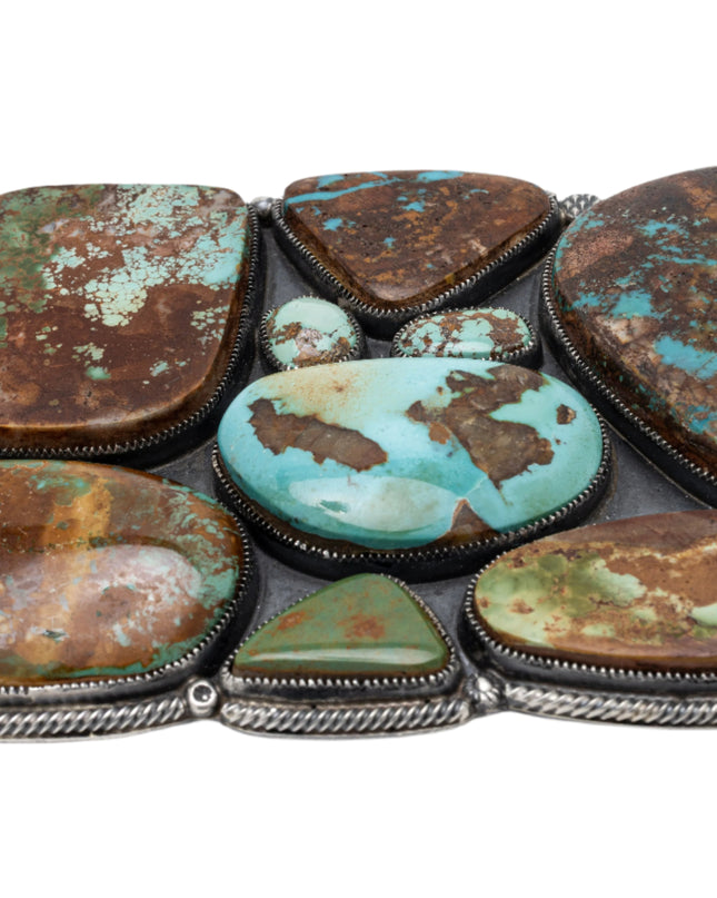 Belt buckle with nine Royston genstones inlay on a white background