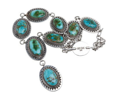 Native American sterling silver necklace with turquoise stones on a light gray background