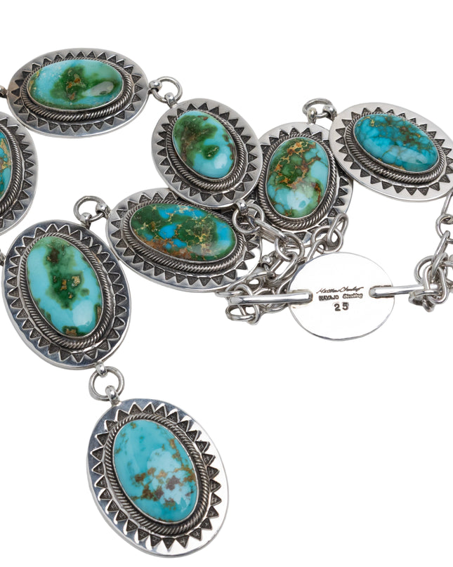 Native American sterling silver necklace with turquoise stones on a light gray background