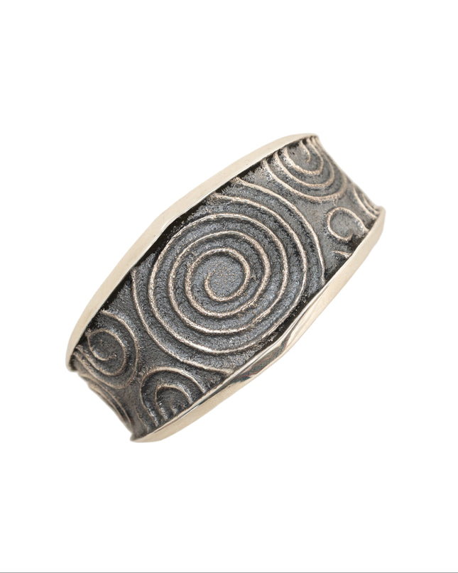 Silver cuff bracelet with spiral pattern on a white background