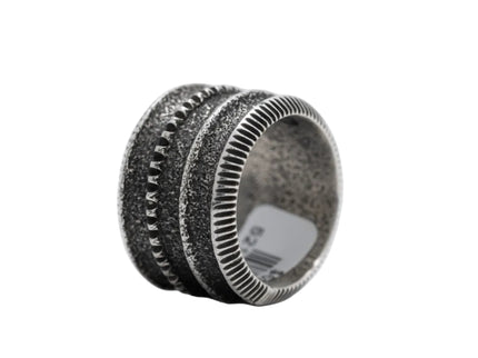 Navajo silver ring with textured rings design on a light gray background