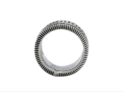Side profile of a Navajo silver ring with a coin edged band on a white background