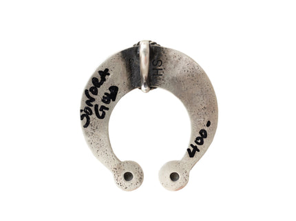 Back side of Silver u-shaped jewelry piece with the hallmark "HS" and stamp "Sterling" on a light gray background