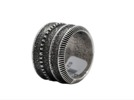 Silver ring with textured design on a white background
