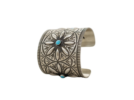 Herman Smith sterling silver cuff with three Beauty turquoise gemstones and hand-stamped patterns sitting upright on a white background