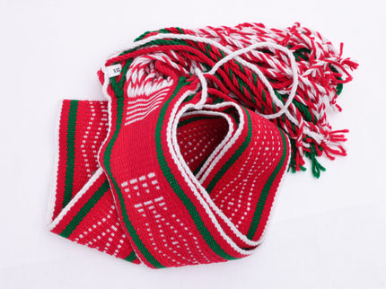 Red and white traditional sash with two green lines laid out on a white background