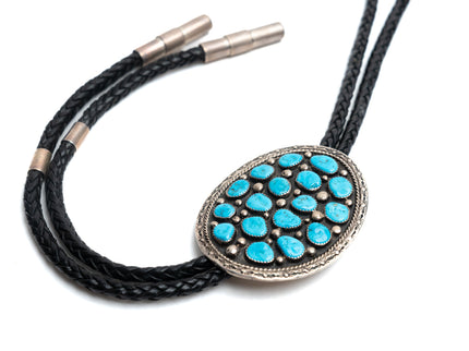 Bolo tie 17 turquoise stones with a black leather strap on a white background