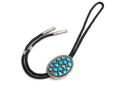 Black leather bolo tie with large circular silver with 17 turquoise stones on a white background