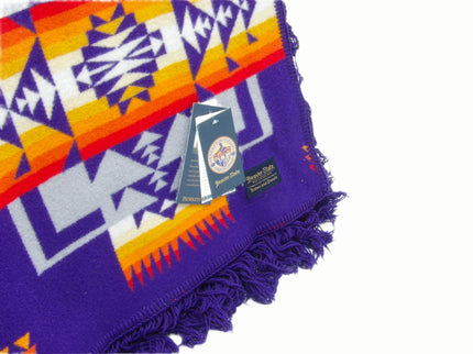 Pendleton Chief Joseph Blanket in purple featuring a traditional Native American-inspired geometric pattern with arrow motifs, folded neatly to show intricate design and soft wool texture, tag view