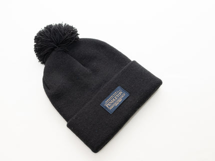 Flat view of a Pendleton classic black beanie with pom-pom and logo on a white background