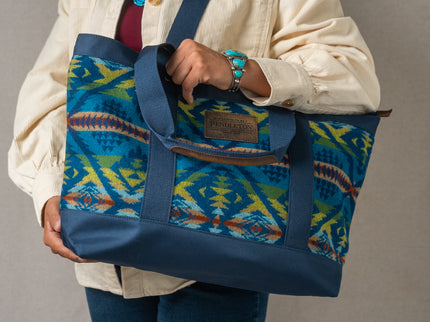 Person holding a blue and green patterned Pendleton tote bag with the Pendleton tag prominent