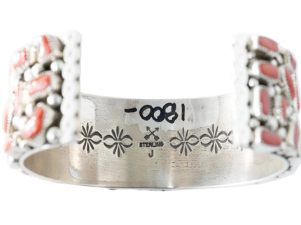 Silver bracelet with coral and white beads on a white background