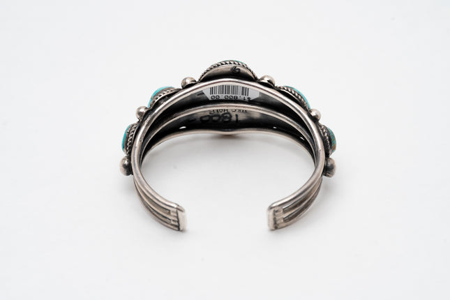Back view of a Native American silver and turquoise bracelet on a white background