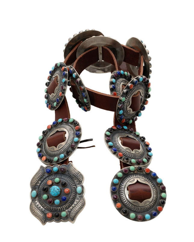 Decorative leather belt with colorful stone embellishments on a white background
