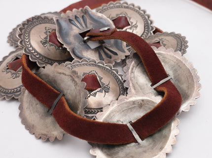 Silver concho belt with brown leather on a white background