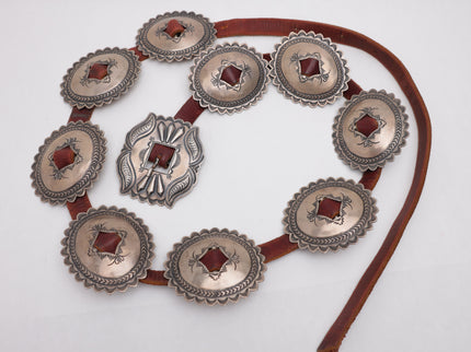 Navajo Concho belt with 9 silver concho plates on brown leather on a white background