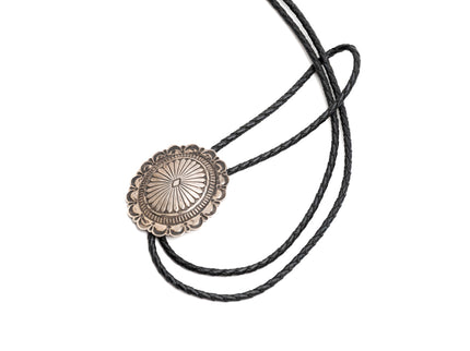 Native American Bolo tie with black leather cord on a white background