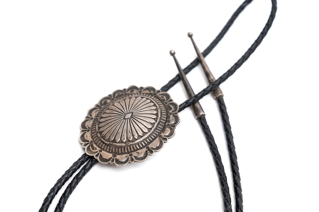 Navajo sterling silver bolo tie with two silver tips on a white background