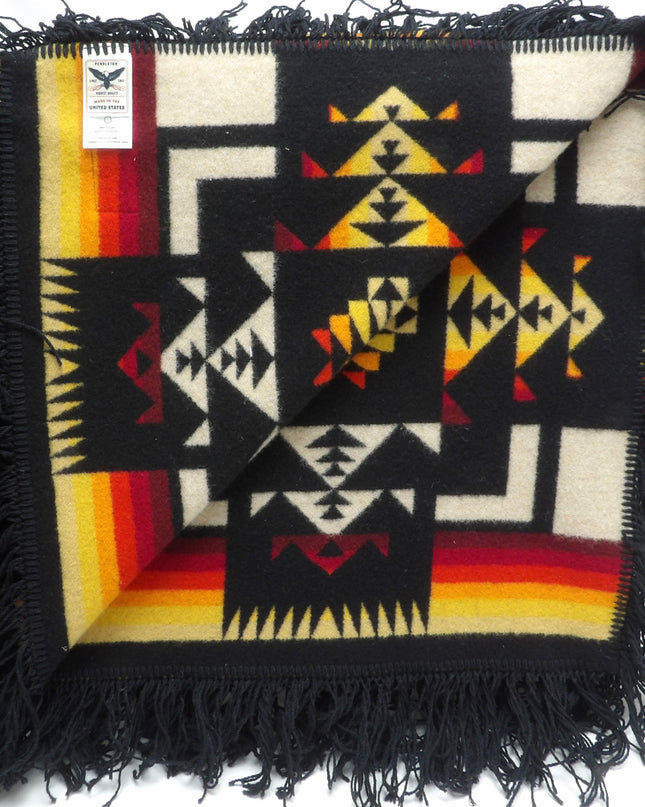 Pendleton Chief Joseph Blanket in Black featuring a traditional Native American-inspired geometric pattern with arrow motifs, folded neatly to show intricate design and soft wool texture. Inside View