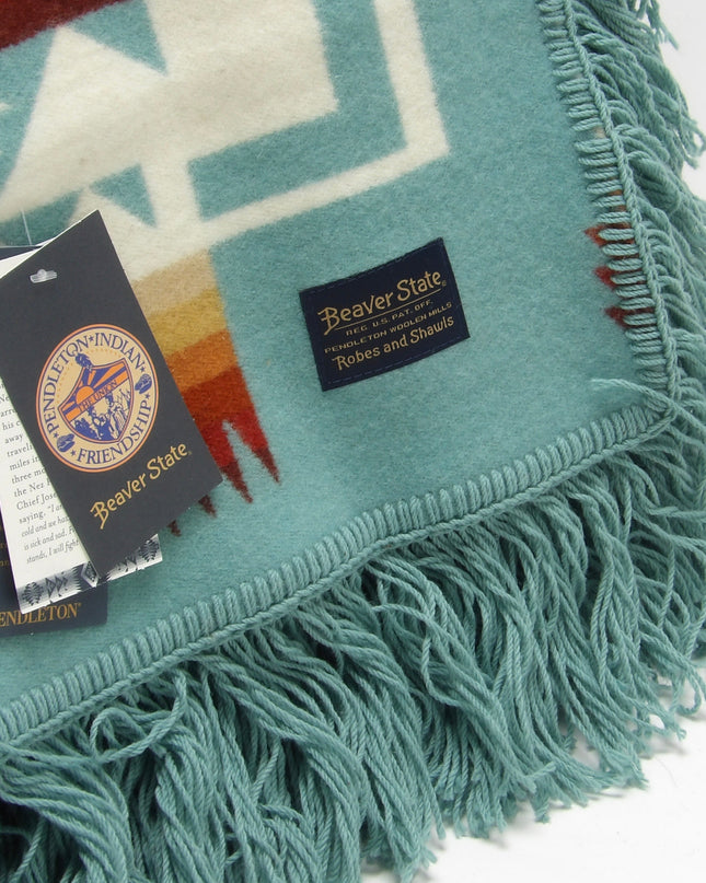 Pendleton Chief Joseph shawl in aqua, featuring a traditional Native American-inspired geometric pattern with arrow motifs, folded neatly to show intricate design and soft wool texture, Tag View