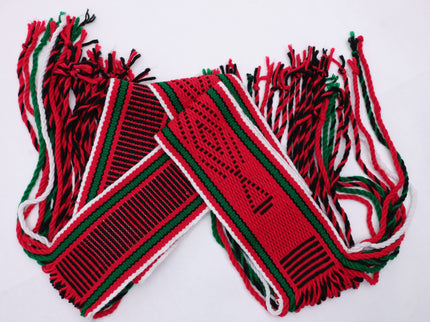 Dark red traditional sash with two green lines and black and white highlights rolled up on a white background