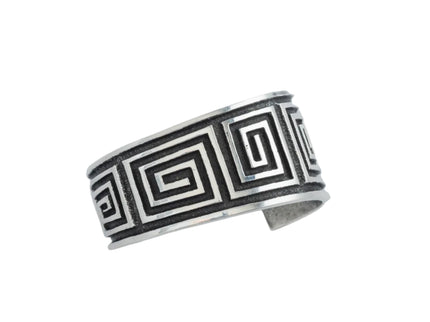 Navajo sterling silver bracelet with black oxidize maze pattern on a light gray background