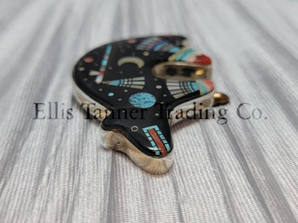 A Native American silver pin with an inlayed bear design featuring various stones such as onyx, mother of pearl, coral, pink shell, and abalone lapis.