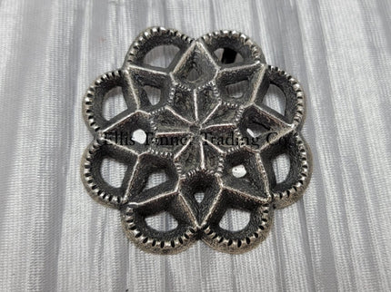 Silver Cut out sand cast, pendant displayed on top of a shiny silver cloth 