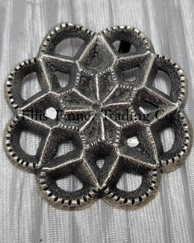 Silver Cut out sand cast, pendant displayed on top of a shiny silver cloth 