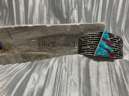Displayed is a silver tufa cobbletone bracelet, on a silver shiny sheet 