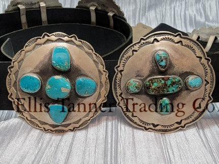 A handcrafted Navajo concho belt with detailed sterling silver conchos, each embedded with mixed turquoise stones of varying shades and natural patterns, attached to a black leather strap.
