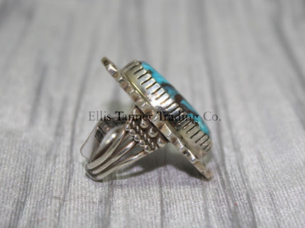 Side profile of a Bisbee Turquoise ring showcasing the raised oval turquoise stone with brown veining, set in a detailed silver bezel. the band’s craftsmanship is visible, emphasizing the ring's dimensional design.