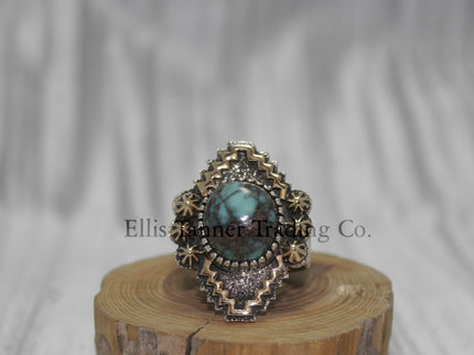 Silver, with zigzag 14k overlay design with round Bisbee turquoise in center, on wooden display