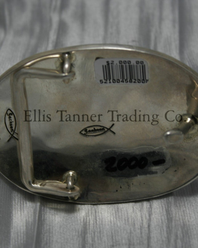 Oval shaped buckle, back side displayed on top of a shiny silver sheet 